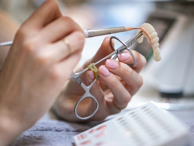 Dental technician finishing a prosthesis at the bench